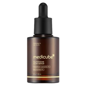 An upright dark brown amber glass bottle of Medicube Glutathione Glow Serum topped with a black matte dropper cap.
