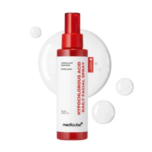 Red spray bottle of Medicube Hypochlorous Acid Daily Facial Spray centered over a translucent liquid splash background.