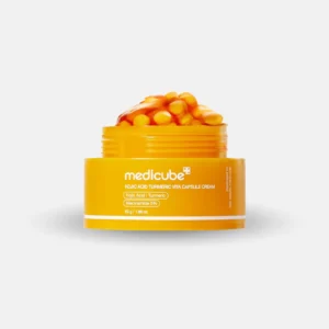 Open bright yellow jar of Medicube Kojic Acid Turmeric Vita Capsule Cream overflowing with gel and cream capsules, accompanied by a gel swatch floating above.