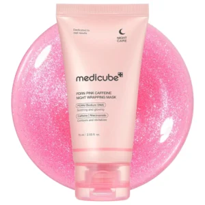 Front view of a soft pink squeeze tube of Medicube PDRN Pink Caffeine Night Wrapping Mask set against a sparkling pink gel backdrop.