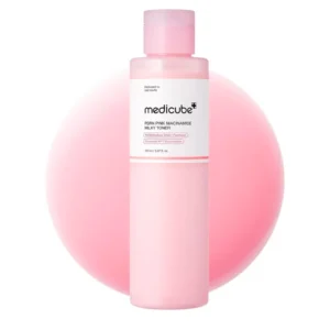 Front view of a pastel pink bottle of Medicube PDRN Pink Niacinamide Milky Toner against a soft pink liquid background.