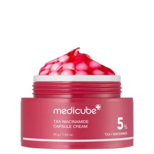 An open magenta tub of Medicube TXA Niacinamide Capsule Cream showcasing pink moisturizer capsules embedded in a clear gel matrix.